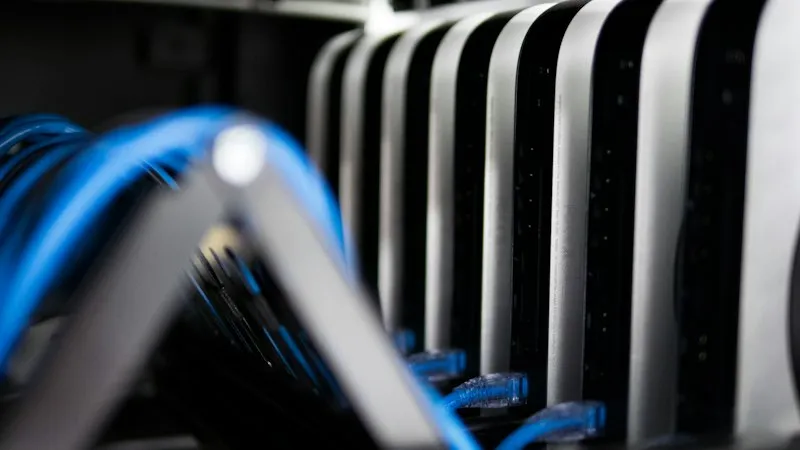 Blue network cables connected to a rack of compact computers